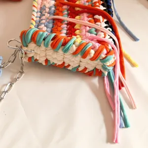 Colorful crochet t-shirt yarn shoulder bag detail, vibrant color-blocking design with chic tassels.
