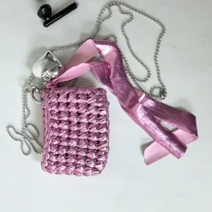 Handmade crochet pink mini earphone bag with silver chain, heart charm, and ribbon accessory.