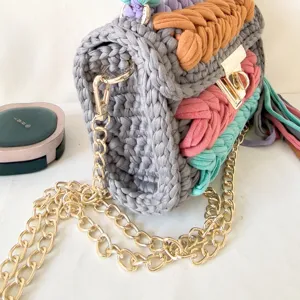 Handmade crochet shoulder bag detail, colorful knitted crossbody bag with gold chain.