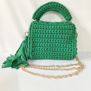 Green handmade crochet shoulder bag detail, fabric woven crossbody purse with gold chain.