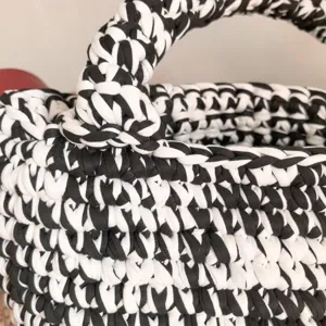 Handmade black and white crochet t-shirt yarn bag detail view, stylish large capacity tote.
