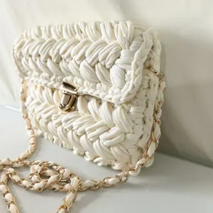Detailed close-up of the handmade crochet crossbody bag highlighting its yarn texture.