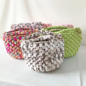 Handgemachte Häkel-Beuteltasche mit bunten Stoffstreifen und schickem Umhängegurt-Design.