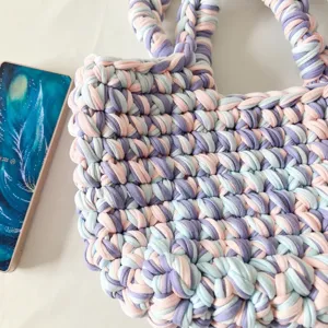 Handcrafted crochet t-shirt yarn handbag with vibrant color-block design, stylish lazy style.