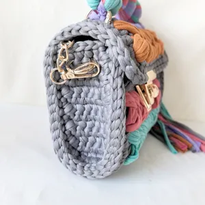 Handmade crochet t-shirt yarn shoulder bag side detail view, colorful woven pattern.