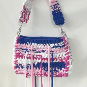 Handmade crochet shoulder bag detail showing multi-color fabric strips and metal chain.