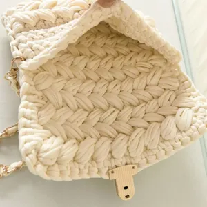 Detailed view of the handmade chunky knit crochet handbag showing textured pattern and gold lock.