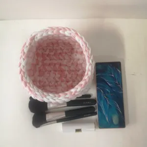 Panier de rangement de maquillage au crochet fait main, organiseur rose et blanc pour cosmetiques.