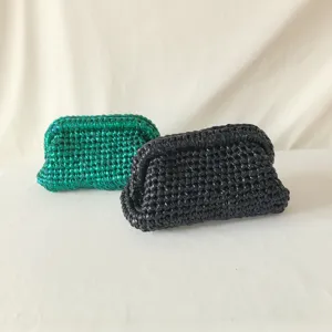 Handmade crochet clutch bag detail, metallic green and black woven fabric purse, stylish design.