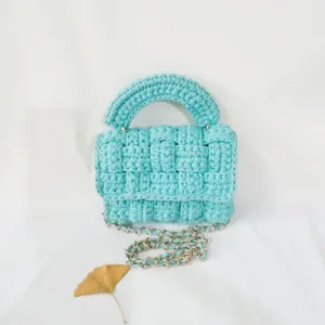 Handmade crochet mini shoulder bag with chain strap, stylish light blue woven crossbody bag detail.