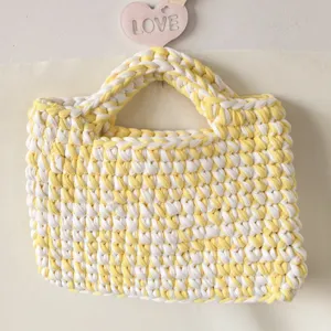 Handcrafted yellow and white crochet small handbag fabric strip woven design detail shot.