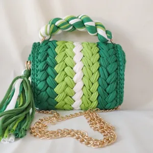 Handmade crochet woven handbag detail, green and white color block design with gold chain.