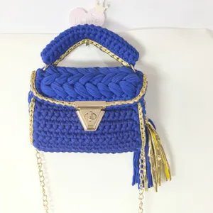Handcrafted crochet shoulder bag with blue fabric yarn, gold trim and chain strap, elegant chic.