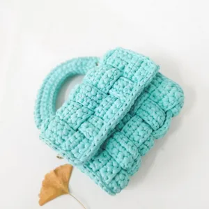 Detail shot of light blue handmade crochet woven handbag showing fine texture and exquisite craft.