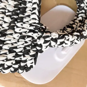 Handmade crochet black and white fabric handbag detail shot, stylish woven texture design.