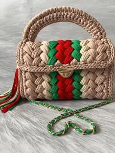 Handmade crochet fabric shoulder bag with stripe pattern, metal lock, and chain strap.