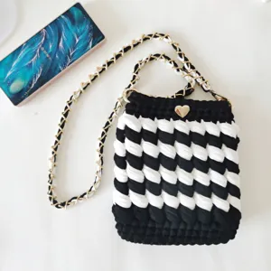 Black and white crochet phone bag detail, stylish crossbody chain handbag with cute heart clasp.