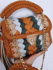 Handmade chunky crochet shoulder bag, colorful woven design with gold chain and metal lock closure.