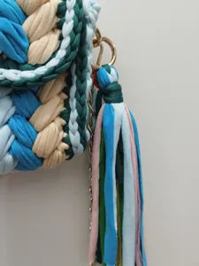 Handgemaakte geweven crossbody tas met kleurrijk gebreid patroon, ketting en kwast.