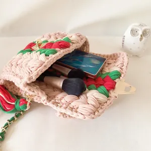 Handmade crochet shoulder bag with colorful blocking, metal lock, and chain strap.