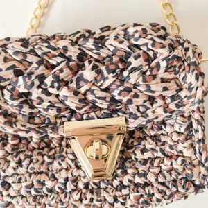 Close-up detail of women's leopard print crochet shoulder crossbody bag with gold chain strap.