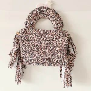 Leopard print crochet handmade handbag close up detail, stylish cloth strip texture design.