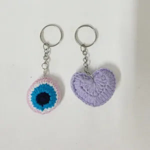 Handmade crochet evil eye and purple heart keychains, cute woven bag charms and accessories.