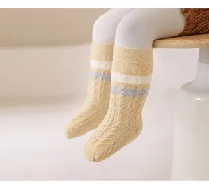 Close-up view of newborn baby winter fleece thickened warm mid-tube socks with cozy stripes.