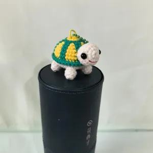 Gros plan détaillé du porte-clés tortue au crochet fait main, joli charm de sac tricoté.