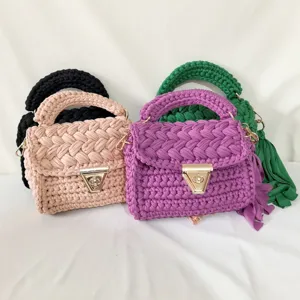 Handmade crochet fabric shoulder bag detail, chunky knit cross body bag with gold clasp.