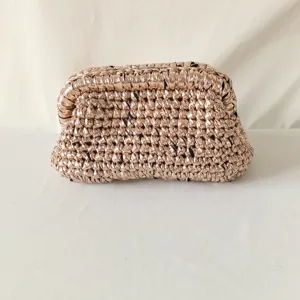 Metallic handmade crochet clutch bag detail, shiny woven fabric purse, elegant evening bag.