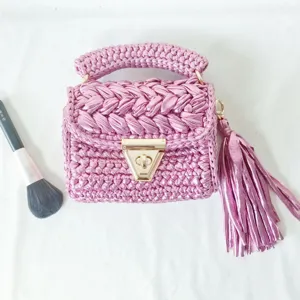 Handmade metallic crochet shoulder bag with unique triangle lock and stylish tassel charm detail.