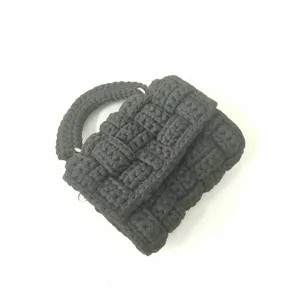 Handmade black crochet mini square bag detail, featuring unique chunky woven fabric design.