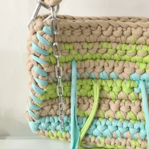 Handmade crochet woven women's shoulder bag detailed view with colorful fabric stripes.