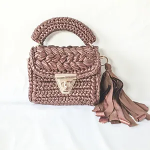 Handmade metallic ribbon crochet shoulder bag with top handle and tassel decoration.