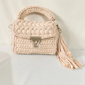 Handmade beige crochet handbag with chunky braided handle, metal turn-lock and stylish side tassel.