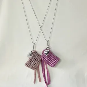 Handmade knitted earphone bag necklace with metal chain, heart pendant and tassel details.