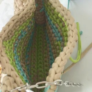 Handcrafted crochet fabric bag interior detail, showing colorful stripe texture and unique design.