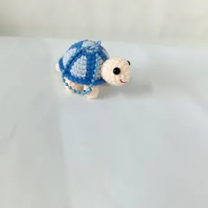 Vue rapprochée détaillée de la jolie petite tortue bleue au crochet comme porte-clés et pendentif.