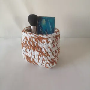 Panier de rangement de maquillage au crochet fait main, organisateur de cosmétiques marron et blanc.