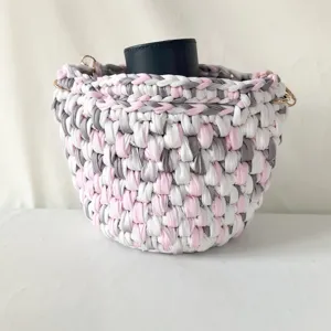 Handgemachte Häkel-Eimer-Umhängetasche mit rosa, grau und weißem Stoffmix Detail.