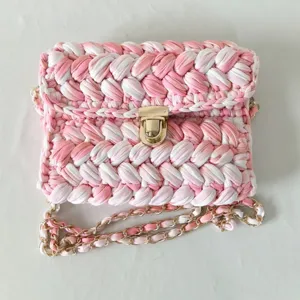 Handmade crochet crossbody bag with pink white gradient fabric yarn and gold chain.