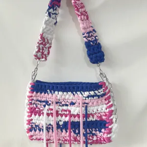 Handmade crocheted fabric shoulder bag detail, colorful striped woven design with fringe.