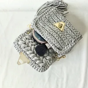 Handmade silver metallic crochet crossbody bag detail showing interior and chic triangular clasp lock.
