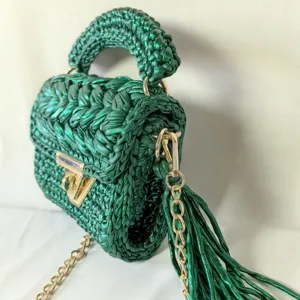Handmade metallic green crochet mini shoulder bag with gold chain and trendy tassel design.