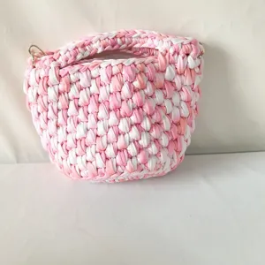 Handgemachte Häkel Eimer Tasche mit rosa weißen und orangen Garnstreifen und Metallringen.