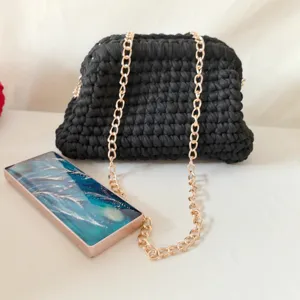 Handmade crochet black clutch bag with gold chain strap, stylish women crossbody bag detail.