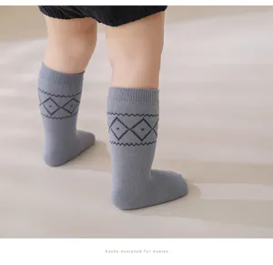 Dettagli di calze al ginocchio per bambini in cotone grigio con classico motivo a rombi.