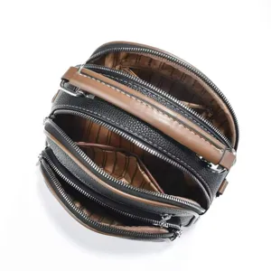 Detailed view showing multi-pocket compartments and smooth zippers of the retro camera bag.