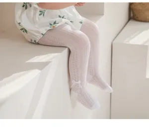 Close-up detail of toddler white mesh tights featuring a cute bow, breathable summer knit.